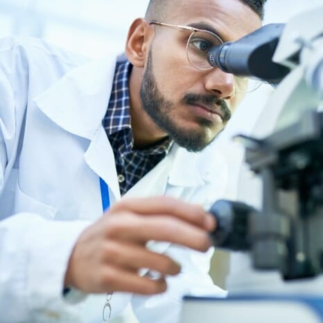 Technician looking into a microscope