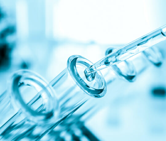 Pipette putting liquid into test tubes in a pharmaceutical laboratory